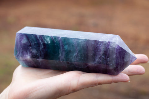 A large Rainbow Fluorite Tower with purple banding at the top.